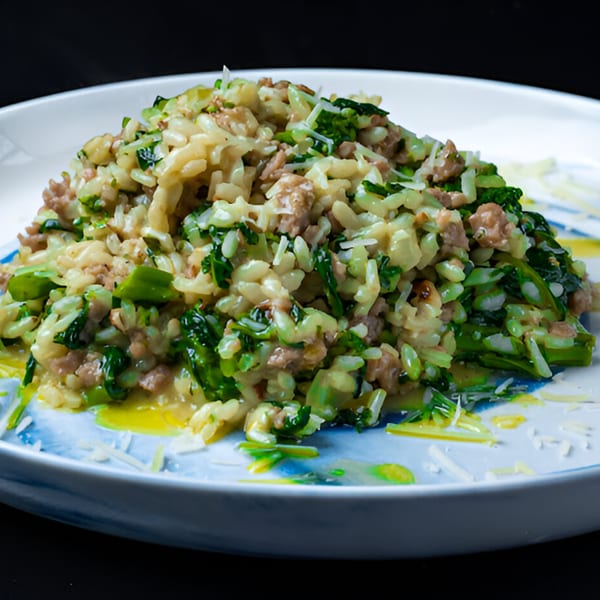 A close-up of The 808 Bistro's Italian risotto with sausage, broccoli rabe, and parmesan cheese.