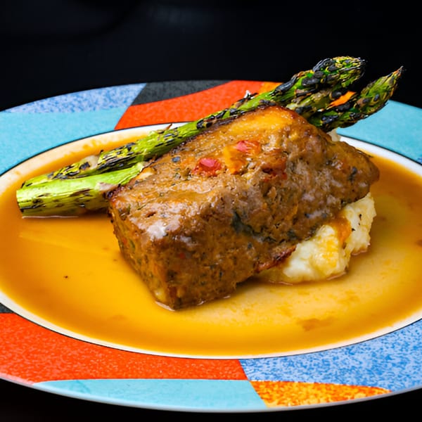 Braised short rib with mashed potatoes and grilled asparagus on a colorful plate at The 808 Bistro.